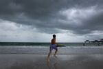 Storm clouds hang over people as they enjoy the beach before the possible arrival of Hurricane Idalia on August 29, 2023 in Clearwater Beach, Florida.