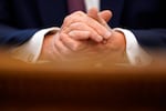 President Donald Trump clasps his hands as he speaks in the Oval Office of the White House in Washington. Trump acknowledged that from early on he was intentionally “playing down” the threat from the coronavirus outbreak that has gone on to kill more than 190,000 Americans. 