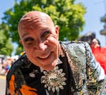 Mr. Mitchell, a cast member of Darcelle XV Showplace, cruises along the parade route in a convertible car.