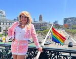D'Arcy Drollinger, the country's first drag laureate, poses with the Pride flag outside San Francisco City Hall on June 2, 2023.