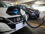 Electric vehicles are displayed at a news conference with White House Climate Adviser Gina McCarthy and Secretary of Transportation Pete Buttigieg in Washington, D.C., on April 22, 2021. The Biden administration's climate and health care bill passed by Congress last week revamps a tax credit for buyers of electric cars.