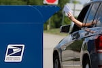 FILE - In this Aug. 19, 2020, file photo, a person deposits mail in a box outside United States Post Office in Cranberry Township, Pa.