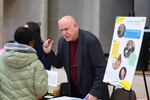 Employers speak with attendees during a job fair at the YMCA Gerard Carter Center in Staten Island in New York City on March 27, 2025. Employers continued to add jobs in March, but uncertainty over trade policy and softer spending by consumers could soon be a drag on hiring. 