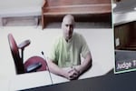 Arson suspect Aaron Farinacci waits for his initial court appearance by video at the county courthouse in Spokane, Wash., Tuesday, Aug. 4, 2026.