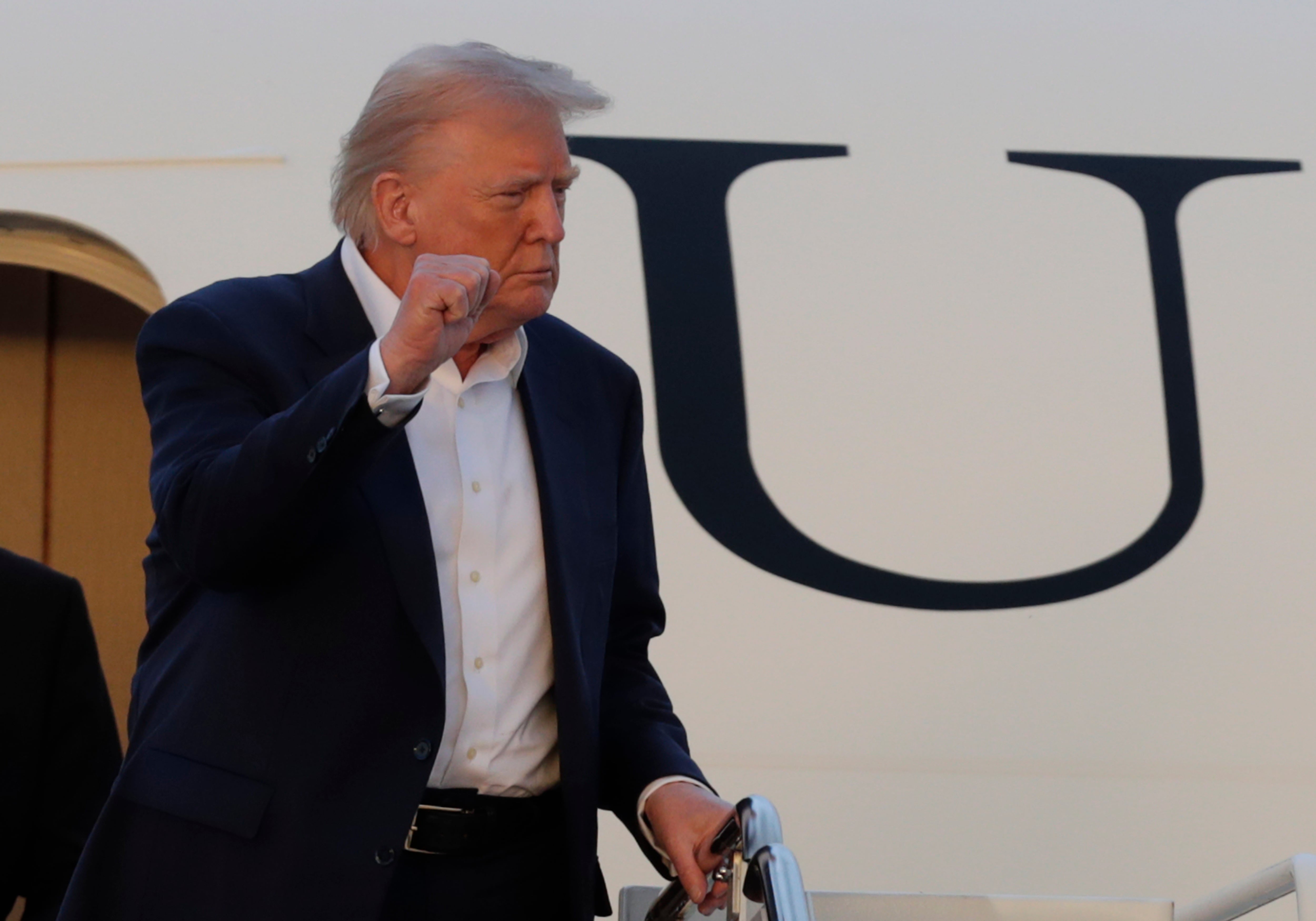 President Donald Trump gestures from the stairs of Air Force One upon his arrival at Joint Base Andrews, Md., Sunday, May 4, 2025.