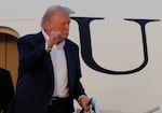 President Donald Trump gestures from the stairs of Air Force One upon his arrival at Joint Base Andrews, Md., Sunday, May 4, 2025.