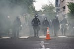 Portland police used tear gas and rubber bullets to disperse protesters from near the Justice Center an hour before the 8 p.m. curfew went into effect on May 30, 2020. The protests were against racist violence and police brutality in the wake of the killing of George Floyd by a white Minneapolis police officer.