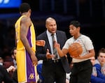 New York Knicks coach Derek Fisher, center, argues a call with official Violet Palmer, right, as Los Angeles Lakers' Ed Davis, left, waits for the ball during the first half of an NBA basketball game, Thursday, March 12, 2015, in Los Angeles.