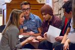 Source Weekly Editor Nicole Vulcan speaks with students Will Anderson and Isaac Cruz before they read their essays at the Student Voices event.