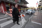 A member of the emergency services walks past a police barricade after a vehicle drove into a crowd on New Orleans' Canal and Bourbon Street, Wednesday Jan. 1, 2025.