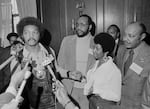 This March 26, 1972 file photo shows the Rev. Jesse Jackson speaking to reporters at the Operation PUSH Soul Picnic in New York as Tom Todd, vice president of PUSH, from second left, Aretha Franklin and Louis Stokes.