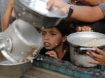 A Palestinian boy watches his portion of food aid ahead of the upcoming Eid al-Adha holiday in Jerusalem, Saturday, June 15, 2024.