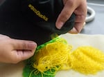 Megan Van Pelt holds one of her latest beading projects — an old University of Oregon hat. Van Pelt took up beading as one way to connect with her Native American heritage.