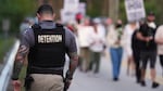A Krome Detention Center officer patrols as people hold a vigil to recognize those who have died in U.S. Immigration and Customs Enforcement custody as well as those affected by mass deportations on May 24 outside Krome Detention Center in Miami.