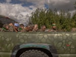 A Ukrainian military vehicle filled with captured Russian troops travels on the Ukrainian side of the border with Russia on Tuesday. Ukraine's President Volodymyr Zelenskyy says Ukraine has captured hundreds of Russian fighters since it launched its invasion into the Kursk region of western Russia on Aug. 6.
