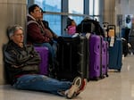 Travelers wait next to their luggage near the Southwest Airlines baggage claim area at the Nashville International Airport after the airline cancelled thousands of flights in Nashville, Tennessee, on Tuesday.