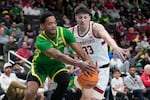 Oregon forward Kwame Evans Jr., left, reaches for the ball next to Stanford forward Evan Stinson (33) during the second half of an NCAA college basketball game in the San Jose Tip-Off in San Jose, Calif., Saturday, Dec. 21, 2024.