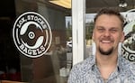Maxwell Davis, the president and owner of Lox, Stocks & Bagels, stands outside his business while a crew from
"America's Best Restaurants" films patrons and staff inside on June 30, 2026.