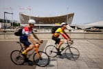 FILE - Cyclists ride near the Aquatic Center in Saint-Denis, north of Paris, July 10, 2023, in Paris. The venue will host artistic swimming, diving and water polo during the Olympics.