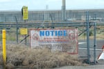 FILE - Caution signs are shown at a gate on the Hanford Nuclear Reservation, Thursday, June 2, 2022, during a tour of the facility in Richland, Wash. by Washington Gov. Jay Inslee.