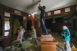 A man tries to take a lamp as people search for belongings in the ransacked private residence of Syrian President Bashar Assad in the Malkeh district of Damascus, Syria, on Sunday.