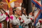 A row of Native American representatives present their tribal flags at the 2022 White House Tribal Nations Summit with President Biden.