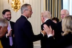 Senate Majority Leader John Thune, R-S.D., greets President Trump as he arrives to speak with Senate Republicans at a breakfast in the State Dining Room of the White House on Nov. 5, 2025.