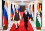 In this pool photograph distributed by the Russian state agency Sputnik, Russia's President Vladimir Putin and Indian Prime Minister Narendra Modi walk prior to an informal dinner at Modi's residence in New Delhi on Thursday, the first day of the Russian leader's two-day state visit to India. (Photo by Alexander KAZAKOV / POOL / AFP via Getty Images)