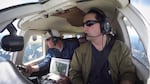 Jeff Lewis (left) listens for signals from below his airplane indicating the presence of fishers below in the Gifford Pinchot National Forest.