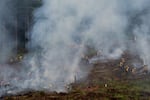 Smoke rises up from controlled burn piles as dozens of trainees work to suppress and mop-up the fires. Many of the firefighters participating were entering their first wildland firefighting season.