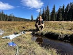 EIS officer Dr. Arran Hamlet  observes a water source being tested for environmental contamination of fecal waste and norovirus.