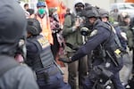 Department of Homeland Security police, along with other federal police, push protesters at the Immigration and Customs Enforcement facility south of downtown Portland on Sunday, Oct. 12, 2025. The top local prosecutor in the Portland area is cautioning against “unreasonable expectations” for charging federal agents under state law.
