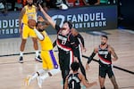 Los Angeles Lakers' LeBron James passes the ball as he is defended by Portland Trail Blazers' Jusuf Nurkic (27) during the second half of an NBA basketball first round playoff game Saturday, Aug. 29, 2020, in Lake Buena Vista, Fla. 