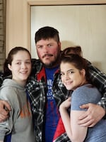 Fredrick Earl Bain stands with his two daughters.