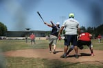 A player smacks a softball toward right field during a slow-pitch tournament at the Friendship Jamboree in Vernonia, Ore., Saturday, Aug. 3, 2019, the Greenman Field grandstands in the background. Activists see the Friendship Jamboree as a key event in the future of the grandstands.