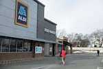 With his back to the camera, Henderson walks through the parking lot at Aldi to return his shopping cart to the grocery store.