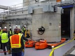 FILE - Workers move a newly-filled cask out of the Waste Encapsulation and Storage Facility on Jan. 20, 2026.