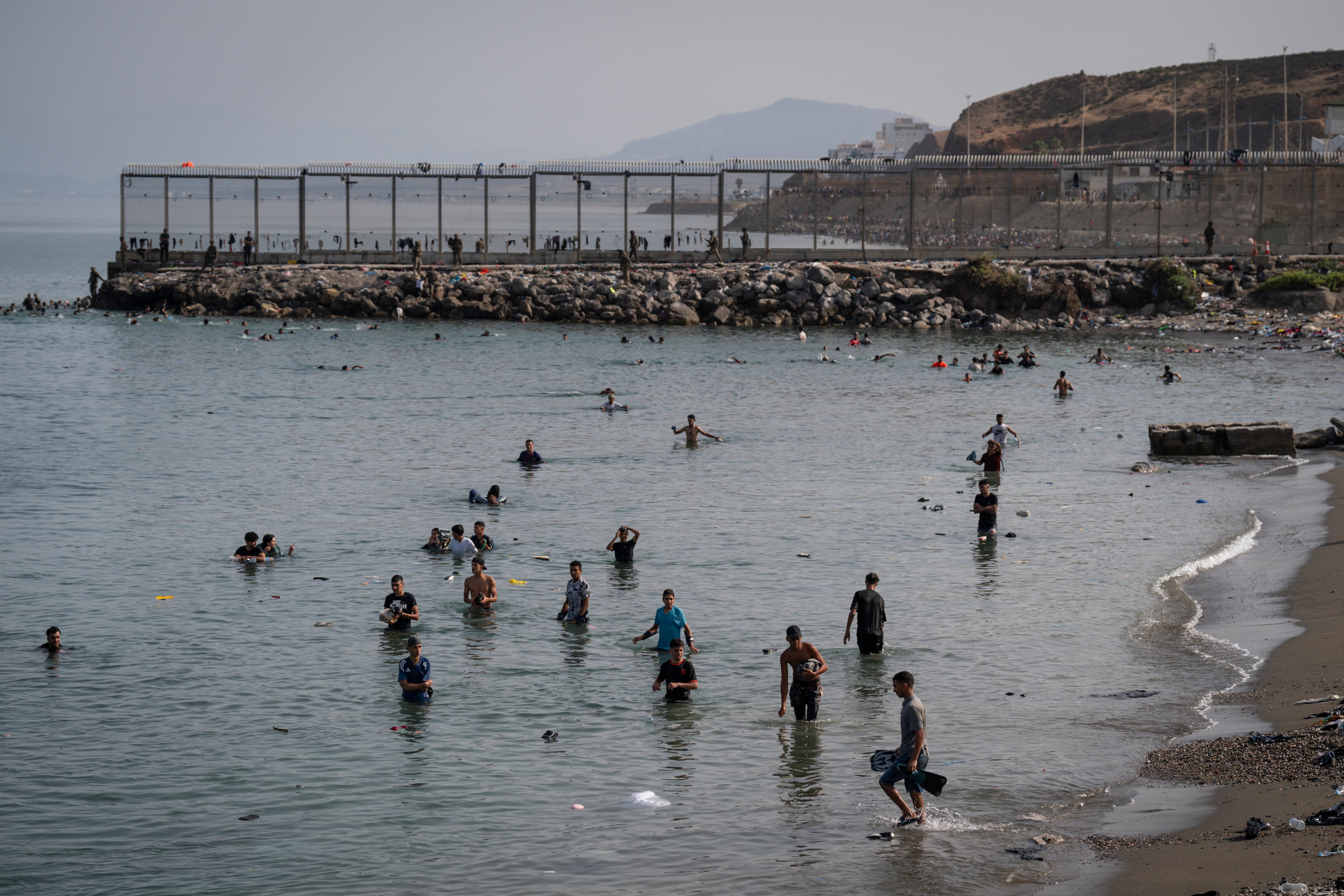 Migrants arrive on Tarajal beach after crossing the border between Spain and Morocco on Friday in Ceuta, Spain. Spain's interior ministry has said it's deploying 60 members of the armed forces and an additional 30 Guardia Civil officers to Ceuta after tens of thousands of migrants entered the Spanish enclave in North Africa on Thursday.