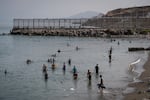 Migrants arrive on Tarajal beach after crossing the border between Spain and Morocco on Friday in Ceuta, Spain. Spain's interior ministry has said it's deploying 60 members of the armed forces and an additional 30 Guardia Civil officers to Ceuta after tens of thousands of migrants entered the Spanish enclave in North Africa on Thursday.