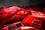 Destroyed homes, illuminated by fire engine lights, are seen after a tornado.