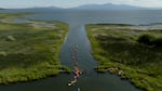 Aerial stills capture a group of kayakers as they attempt a source-to-sea journey along the Klamath River. Kayakers encounter winding river bends, rock formations and rapids.