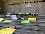 Protesters left signs and flowers outside the Jackson County Justice Building on Friday.