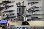 FILE - Firearms are displayed at a gun shop, Feb. 19, 2021, in Salem, Ore. Ballot Measure 114 bans purchases of magazines that can hold more than 10 rounds of ammunition.