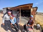 Tuckshop workers Ntsoaki Neqoa, center, and Mapaseka Mohale, left joke with cobbler Tumelo Rakoti at a marketplace near the Levi's Jeans factory in Maseru, Lesotho, on 15 July, 2025.
