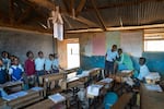 Saidimu, Loshaki and Paris look on as their much younger third-grade classmates sing a song.