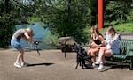 University of Oregon junior Ellie Watson takes video footage of two members of the acrobatics and tumbling team on May 8, 2025, in Eugene, Ore. The two athletes have a partnership with Dutch Bros coffee, and Watson is helping create social media videos.