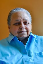 A woman with gray hair smiles at the camera