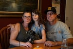 From left to right, Kristan Banks, Phoenix Banks and Damien Banks pose for a portrait in their dining room in Bend, Ore., on Oct. 20, 2026. School is resuming in the Bend-La Pine Schools district on Oct. 21, after being closed for several days following the shooting at Silver Rail Elementary School.