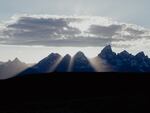 The sun sets behind the Grand Teton Mountains.