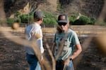 Jared Smull, left, and his wife Amanda stand on burned land at the edge of their rangeland near Durkee, Ore., July 31, 2024. Jared, a fifth generation rancher, says he has never experienced a burn of this scale. He anticipates it will take several years to recover. 